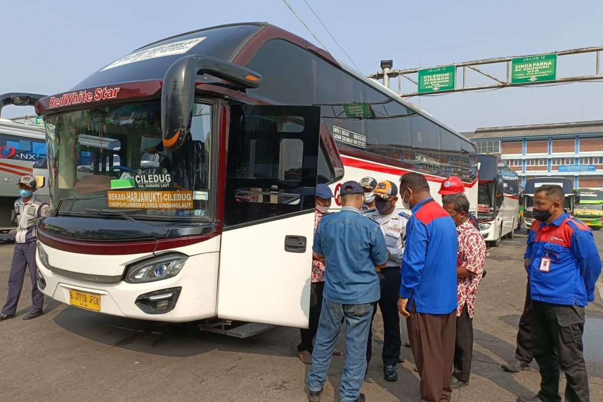 Petugas Dishub melakukan inspeksi keselamatan (ramp check) di Terminal Induk Kota Bekasi terhadap bus-bus yang akan menjadi angkutan pada libur Lebaran 2022, Rabu (13/4/2022). Adapun ramp check dilakukan guna mengantisipasi terjadinya kecelakaan terhadap kendaraan bus pengangkut penumpang yang ingin mudik. (KOMPAS.com/Joy Andre T).