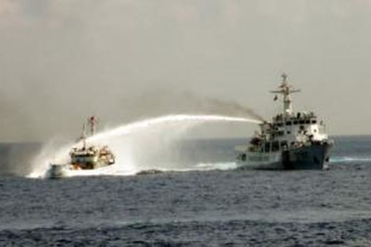 Kapal patroli Vietnam (kiri) terlibat tembak menembak meriam air dengan kapal Tiongkok di perairan sengketa Laut China selatan, Senin 12/5 ).