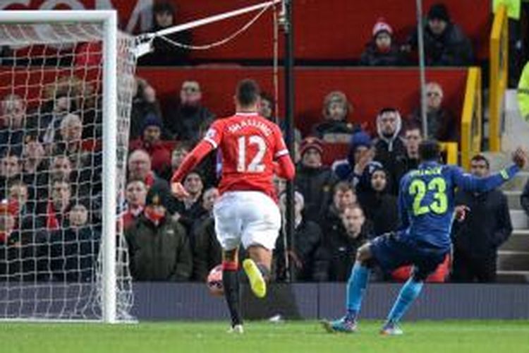 Striker Arsenal, Danny Welbeck (kanan) saat melepaskan tendangan yang berujung gol ke gawang Manchester United pada perempat final Piala FA di Old Trafford, Senin (9/3/2015). 