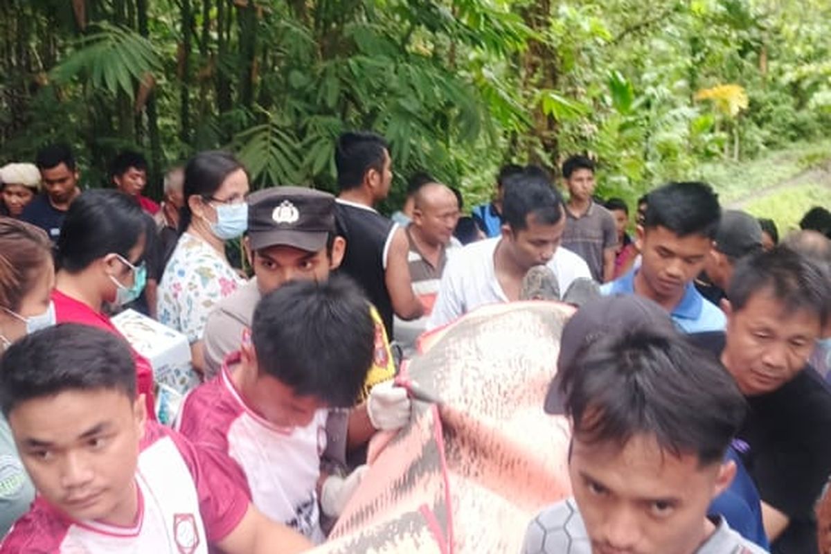  Warga dan polisi saat mengevaluasi jenazah pria inisial FG (64) yang tewas tertimpa pohon saat gotong royong, Jumat (11/4/2025)