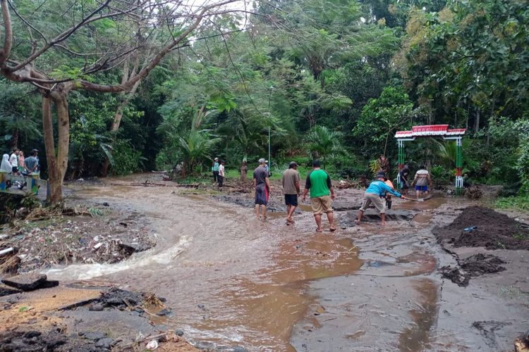 Warga melakukan gotong royong pembersihan material yang dibawa banjir 