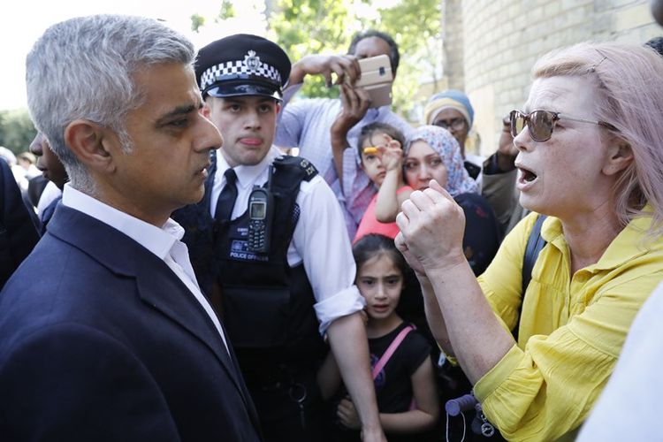 Wali kota London Sadiq Khan mendengarkan protes warga ketika mengunjungi lokasi kebakara Menara Greenfell yang mengakibatkan setidaknya 17 orang tewas.