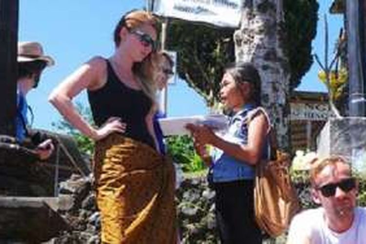 Ni Putu Rista saat menawarkan post card ke wisatawan yang berkunjung ke Besakih, Karangasem, Bali. Ia menggunakan berbagai bahasa. Para wisatawan heran melihat kemampuan berbahasa asing. 