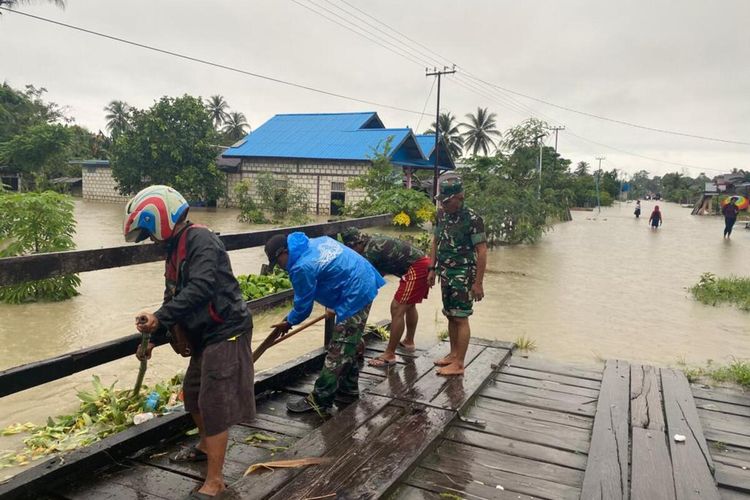 Sejumlah warga dan personel TNI tengah memperbaiki jembatan yang rusak akibat banjir di Nimbokrang, Kabupaten Jayapura, Papua, Minggu (9/1/2022)