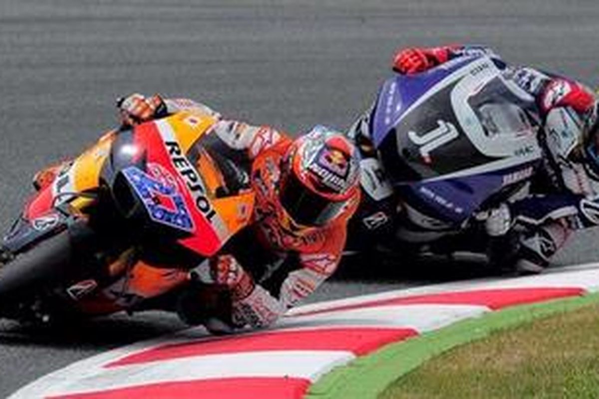 Pebalap Yamaha, Jorge Lorenzo (kanan), bersaing dengan pebalap Repsol Honda, Casey Stoner, di GP Catalunya, Minggu (5/6/11). Lorenzo gagal mengimbangi Stoner sehingga harus puas menjadi runner-up.