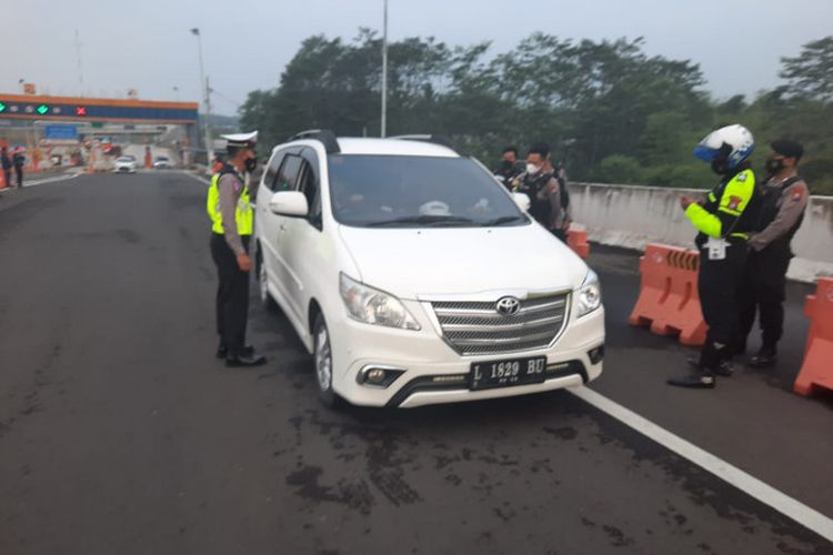 Personel Satlantas Polresta Malang Kota menanyakan salah satu pelaku perjalanan yang melewati Exit Tol Madyopuro terkait pengetatan arus mudik, Sabtu (1/5/2021).