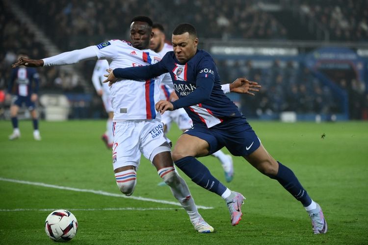 Kylian Mbappe saat berebut bola dengan bek Lyon, Sinaly Diomande, dalam pertandingan PSG vs Lyon pada pekan ke-29 Liga Perancis 2022-2023 di Stadion Parc des Princes, Senin (3/4/2023) dini hari WIB. (Foto oleh FRANCK FIFE / AFP)