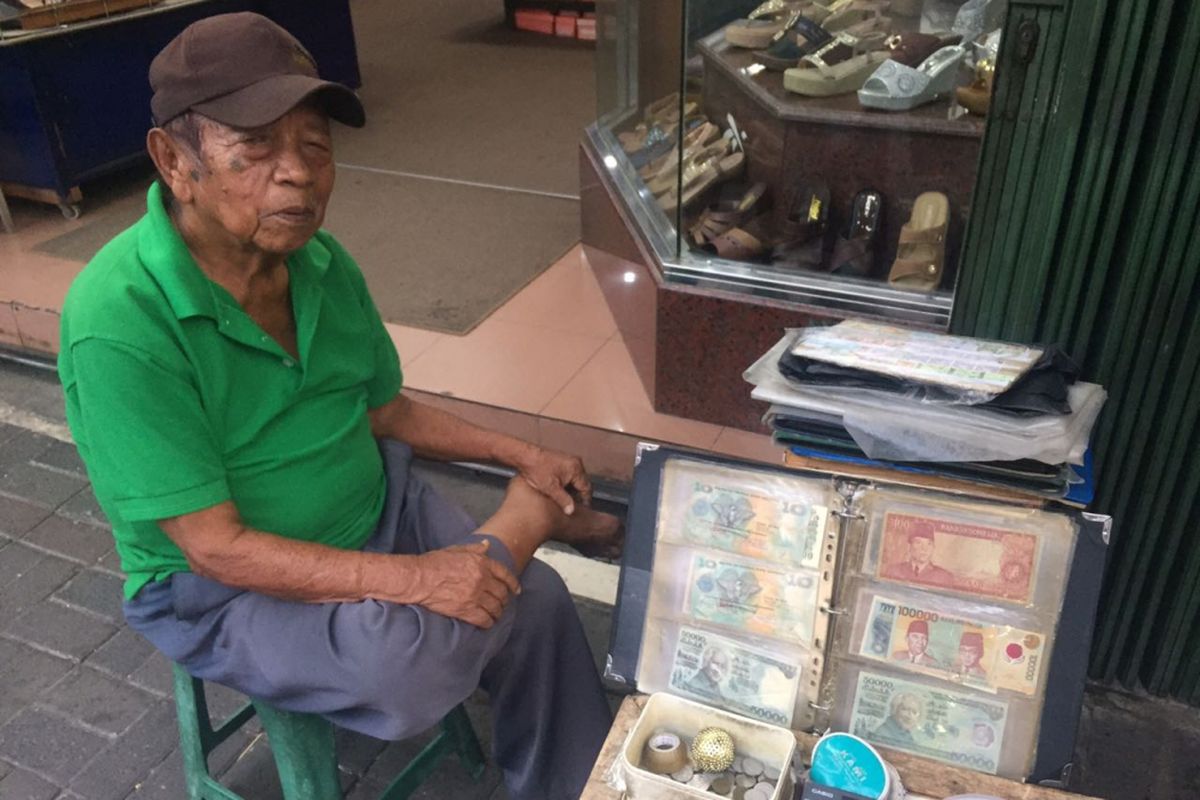 Syamsir (79), salah satu penjual uang kuno di kawasan Pasar Baru, Jakarta  Pusat telah menekuni profesi tersebut selama 28 tahun. Dari menjual uang kuno, Syamsir bisa menghidupi serta menyekolahkan 7 anaknya hingga lulus bangku SMA, Senin (11/6/2018). 