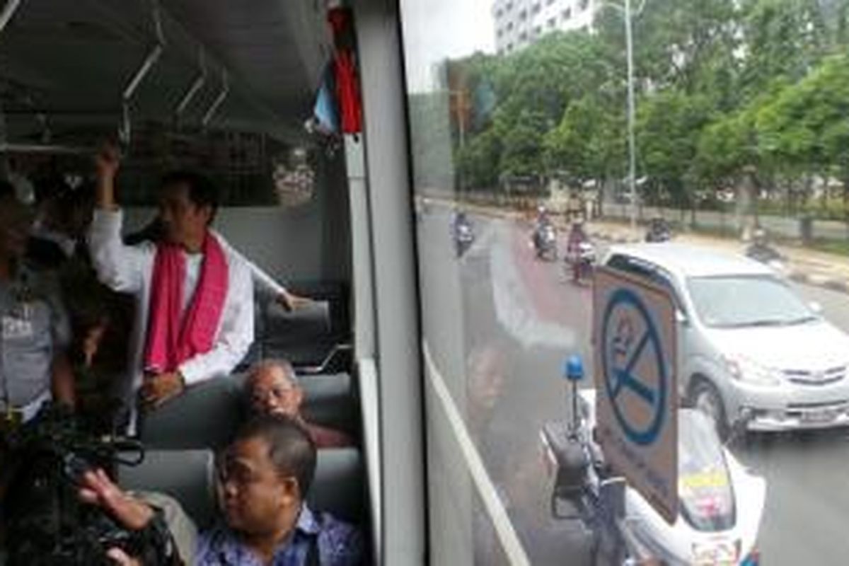 Gubernur DKI Jakarta Joko Widodo (kanan) dan Kepala Dinas Perhubungan DKI Udar Pristono (kiri) berdiri di dalam bus Angkutan Perbatasan Terintegrasi Busway atau APTB di selter Slipi-Petamburan, Jakarta, Jumat (24/1/2014) siang.