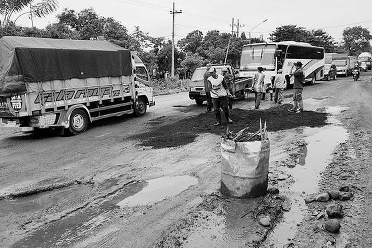 Pekerja memperbaiki jalan rusak di ruas jalan Pasuruan-Probolinggo di Kecamatan Nguling, Pasuruan, Jawa Timur, beberapa waktu lalu. Selain menghambat transportasi antarkota di Jawa Timur, lubang-lubang yang banyak terdapat di ruas jalan tersebut membahayakan pengendara sepeda motor, terutama pada malam hari dan saat hujan.