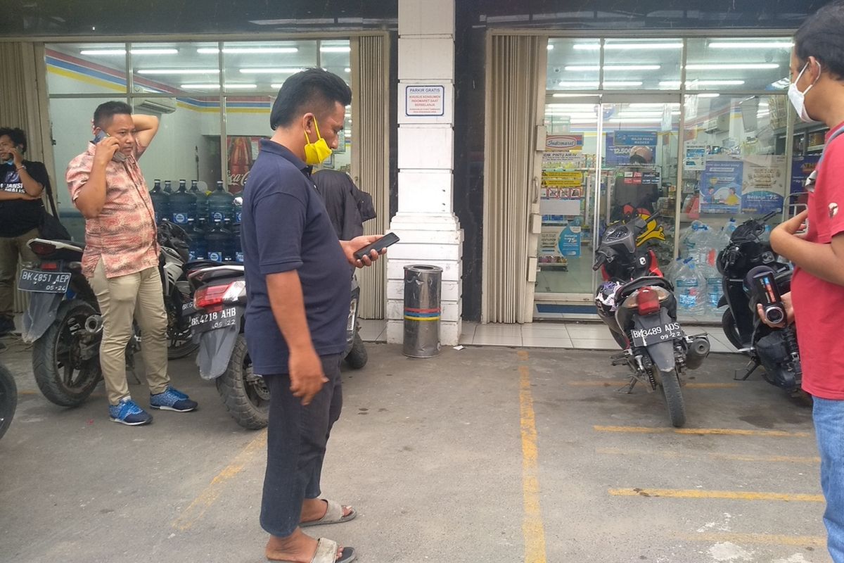 Kepala Lingkungan II, Kelurahan Kwala Bekala, Kecamatan Medan Johor, Budi Sitepu (kiri) sedang menghubungi seseorang di depan mimimarket di Jalan Pintu Air IV, tempat terjadinya penganiayaan anak remaja oleh seorang pria yang videonya viral di media sosial. Penganiayan itu terjadi karena pelaku diduga tidak terima disuruh menggeser mobilnya oleh korban yang sepeda motornya ditabrak oleh pelaku dan terhalang di parkiran.