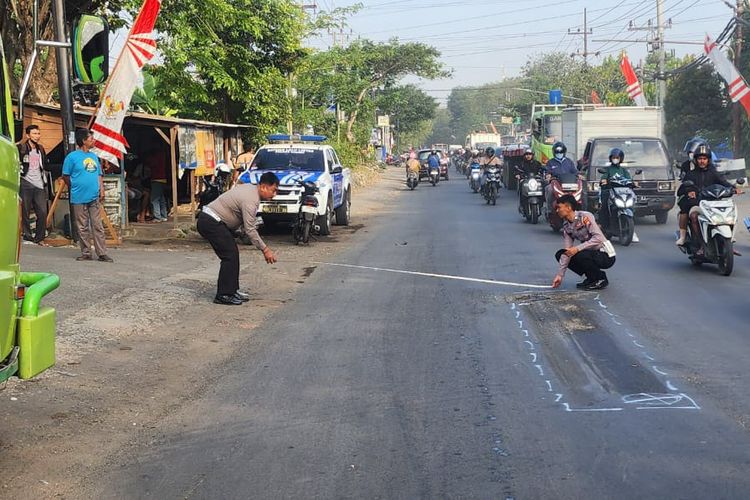 Petugas kepolisian melakukan olah TKP lokasi kecelakaan lalu lintas di Jalan Raya Mayjen Sungkono, Kelurahan Gending, Kecamatan Kebomas, Gresik, Jawa Timur, Jumat (9/8/2024).