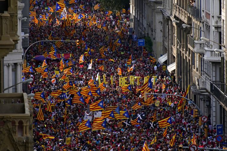 Demonstran berbaris memegang bendera pro-kemerdekaan selama Hari Nasional Catalonia di Barcelona, Spanyol, Sabtu, 11 September 2021. 