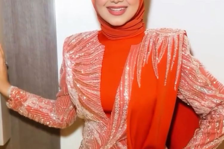 Siti Nurhaliza tampil memukau di Pestapora 2025 dengan hijab oranye terang, setelan berpayet, dan makeup soft glam yang elegan.