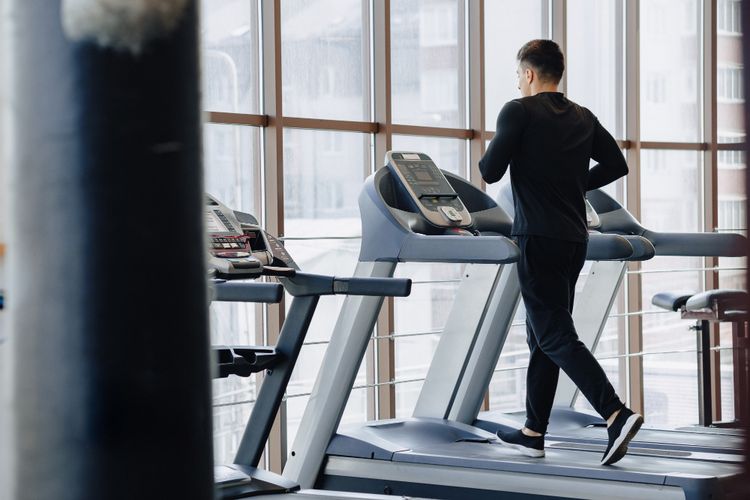 Ilustrasi pria sedang berolahraga di atas treadmill.