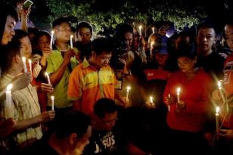 Warga memegang lilin sambil berdoa untuk para terpidana mati di Pelabuhan Wijayapura, di Cilacap, Jawa Tengah, Rabu (29/4/2015) dini hari. Delapan terpidana mati kasus narkoba telah dieksekusi mati secara serentak di Nusakambangan, Jawa Tengah, pukul 00.25. Sementara itu eksekusi terhadap Mary Jane ditunda. 