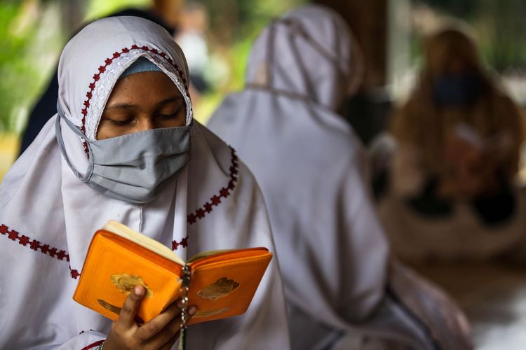 Santri putri mengaji di Pondok Pesantren An Nuqthah, Kota Tangerang, Banten, Kamis (18/6/2020). Pondok pesantren An Nuqthah kembali melaksanakan aktivitas setelah libur panjang akibat COVID-19 dengan menerapkan protokol kesehatan dan pengecekan kesehatan bagi santri yang baru tiba.