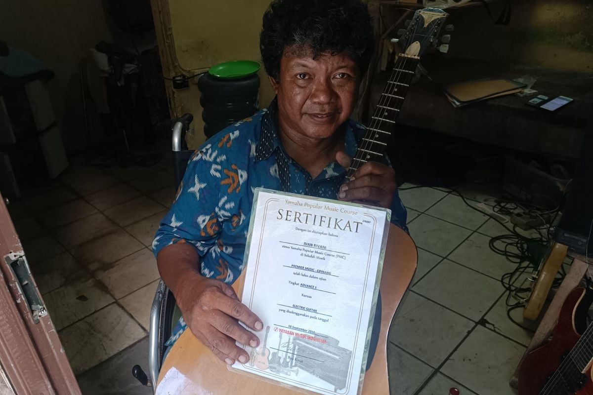 Ivan Rivani (51), penyandang tuna daksa yang membuka les gitar keliling, di kediamannya di Cipinang, Pulogadung, Jakarta Timur, Jumat (20/10/2023).