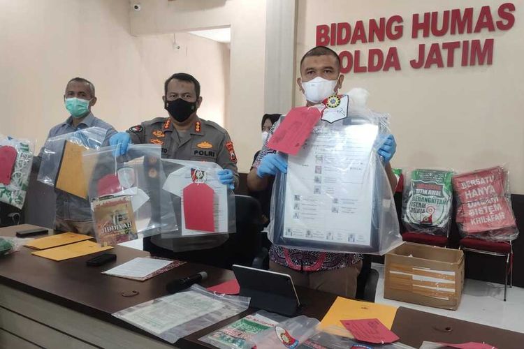 Polisi menunjukkan barang bukti yang diamankan dari kantor Khilafatul Muslimin Surabaya.