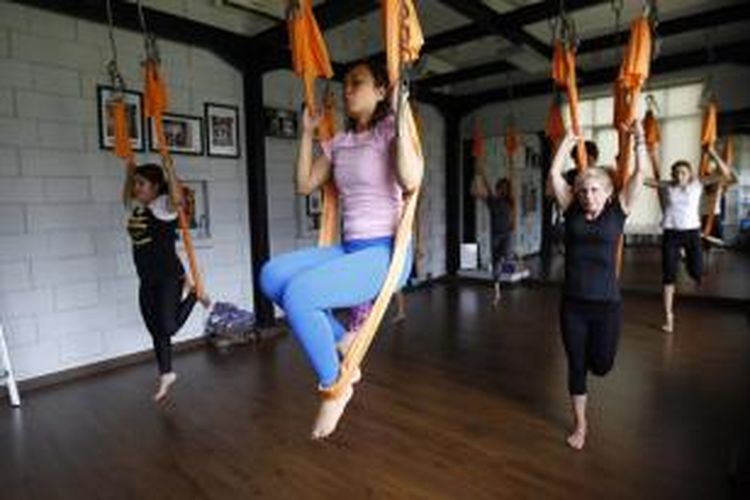 Peserta swing yoga melakukan gerakan yoga di Yogasana Studio, Plaza Arcadia, Senayan, Jakarta, Kamis (5/3/2015). Swing yoga atau juga dikenal dengan antigravity yoga adalah olahraga yoga yang menggunakan hammock sebagai alat bantu melakukan gerakan yoga.