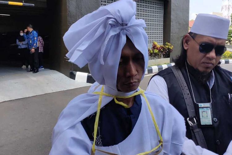 Rian Antoni (40) pocong yang jadi tersangka kasus pencabulan saat berada di Polda Sumatera Selatan, Senin (22/5/2023).