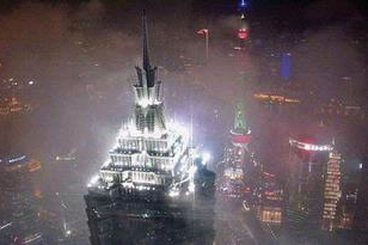 Dari lantai 94 gedung Shanghai World Financial Center, Kota Shanghai serupa kunang-kunang di tengah kabut musim dingin.