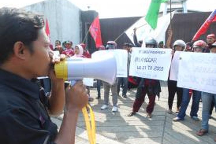 Para buruh menggelar aksi solidaritas, menuntut lima temannya yang dirumahkan oleh manajemen PT. Lulu Indonusa, agar dipekerjakan kembali, Senin (2/12/2013)