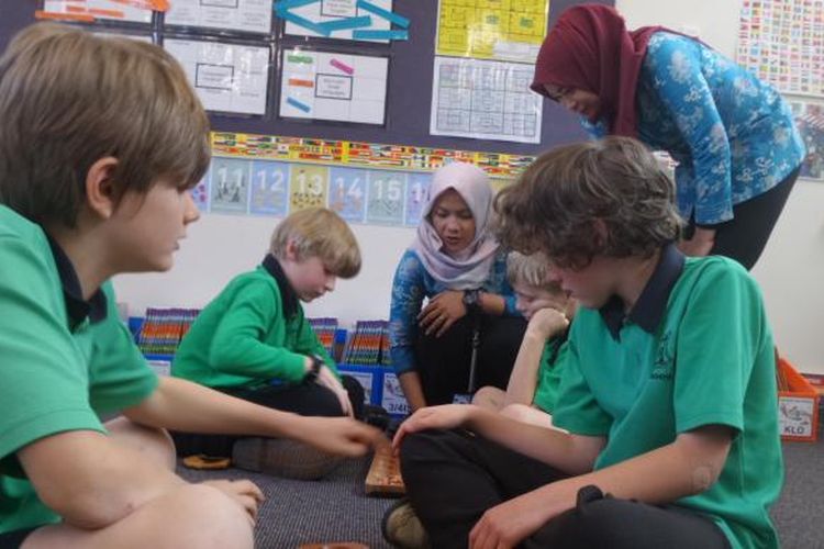 Anak-anak usia sekolah dasar di Turner School mengikuti pelajaran Bahasa Indonesia melalui permainan tradisional congklak. Dyah Candra Arbiningrum dan rekannya, guru dari Pangkalan Bun, Kalimantan Tengah, ikut mengajar sebagai guru pendamping saat mengikuti program Bridge.