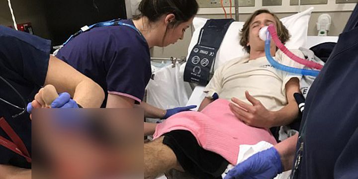 Sam Kanizay, ditangani tim medis saat mengalami pendarahan di kaki setelah keluar dari air, usai berenang di pantai Brighton, di pinggiran Kota Melbourne, Sabtu malam lalu. Darang mengalir tak henti dari pergelangan kaki dan betis remaja itu.  