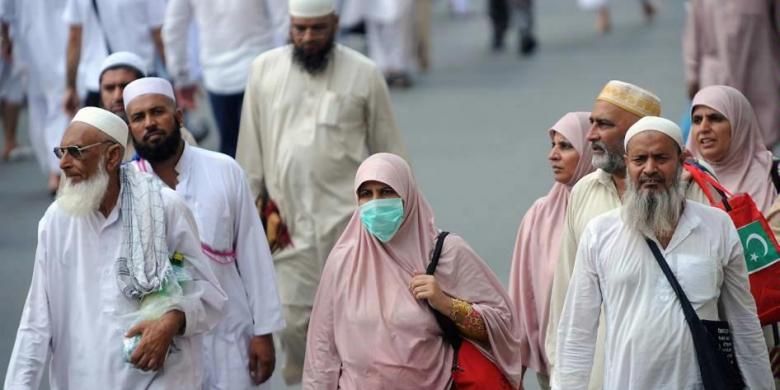 Umat Islam mengenakan masker ketika menuju Masjidil Haram, Kota Mekkah, Arab Saudi, 8 Oktober 2013. Lebih dari dua juta muslim tiba di kota suci ini untuk ibadah haji tahunan.