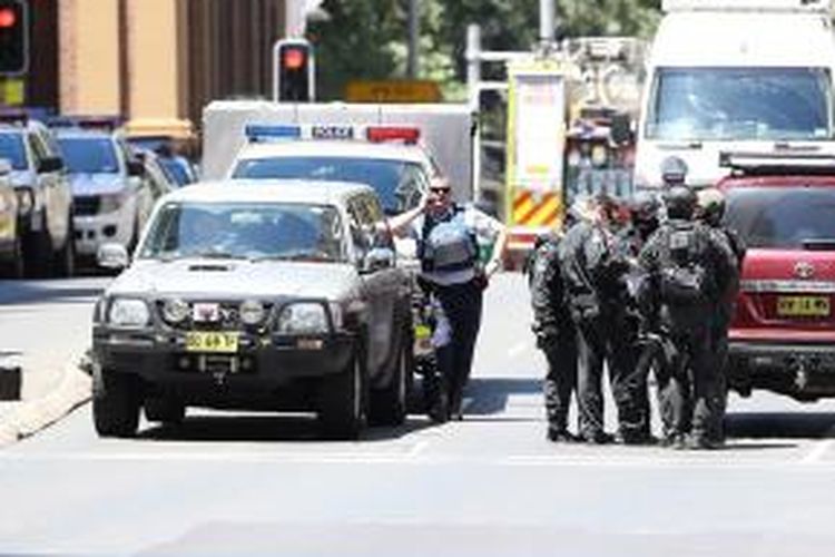 Aparat keamanan Sydney, Australia, menutup daerah sekitar Martin Place saat mereka melakukan operasi pengepungan di sebuah kafe yang telah dikuasi orang bersenjata, Senin (12/12/2014).