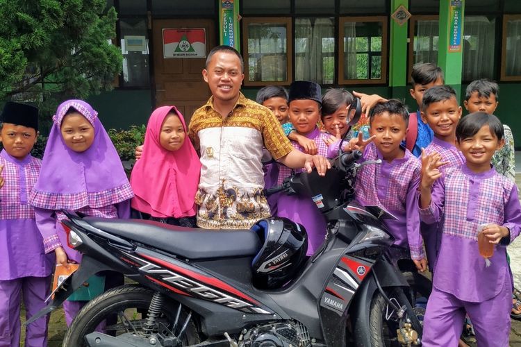 Guru honorer, Panji Setiaji foto bersama sejumlah muridnya di depan sepeda motor hadiah dari SKP di SDN Babakan, Kecamatan Cibeureum, Sukabumi, Jawa Barat, Jumat (31/1/2020).