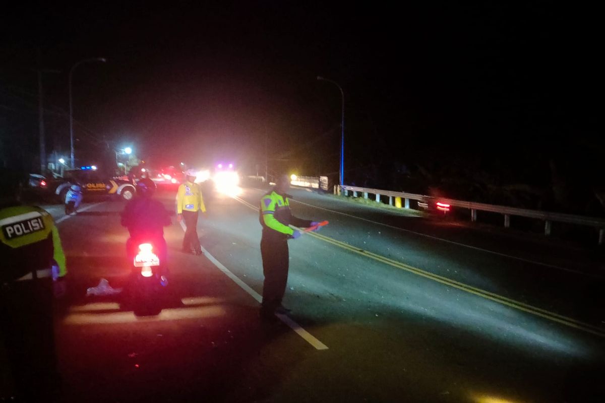  OLAH TKP-Petugas Satlantas Polres Madiun melakukan olah tempat kejadian perkara kecelakaan sepeda motor menabrak bus di ruas jalan Madiun – Surabaya, Desa Garon, Kecamatan Balerejo, Kabupaten Madiun, Jawa Timur, Senin (13/2/2023) malam.