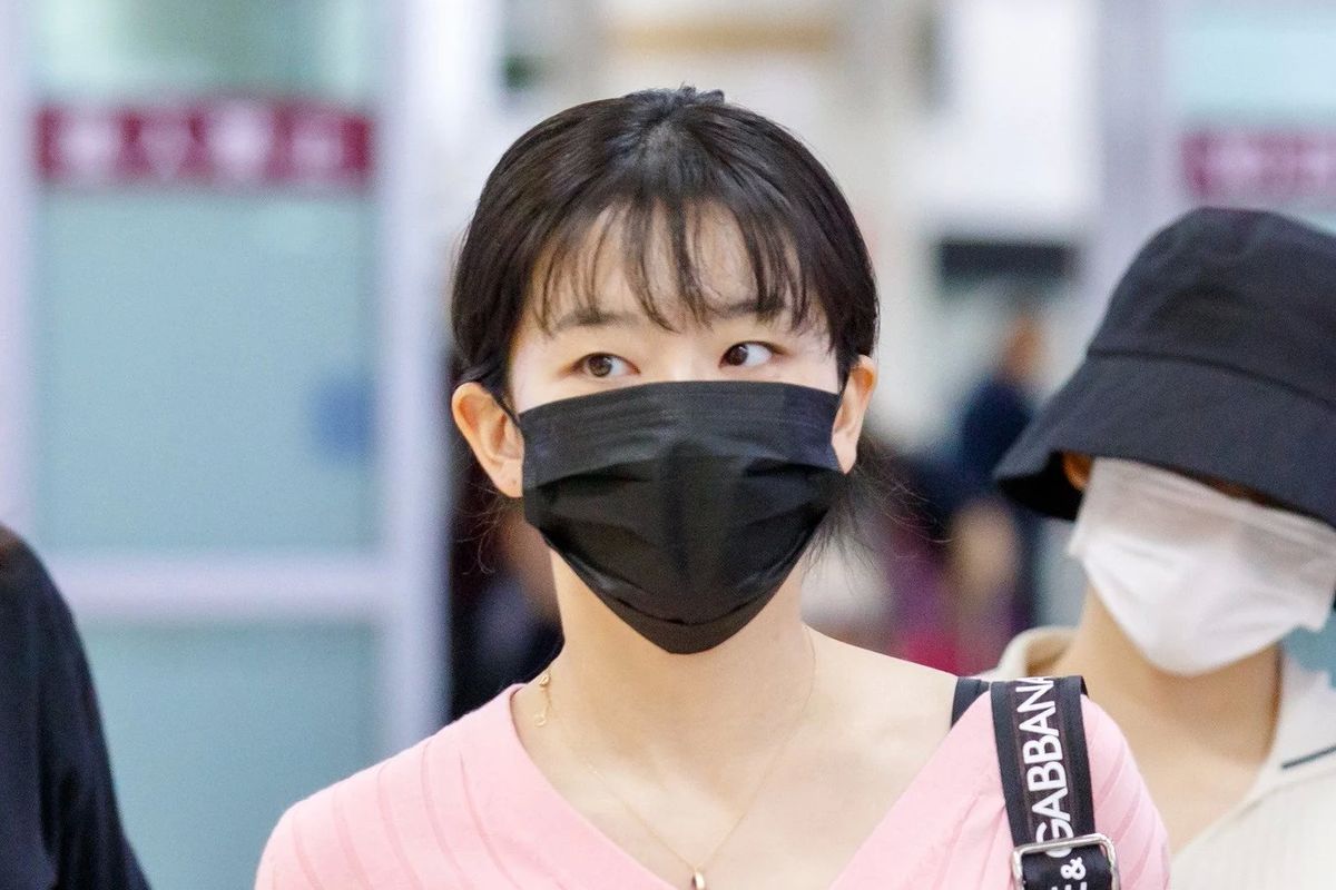 Bintang girlband Red Velvet, Seulgi saat berada di bandara dan mengenakan masker hitam di wajahnya. 