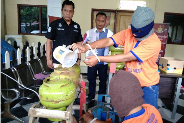 Pelaku mempraktekkan aksi pengoplosan elpiji di hadapan petugas kepolisian dan wartawan. 