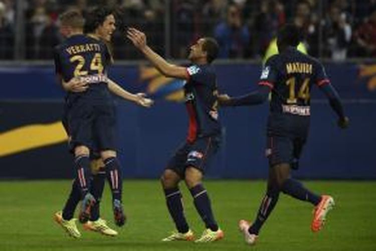 Bomber Paris Saint-Germain, Edinson Cavani, disambut rekannya seusai mencetak gol pada laga final Piala Liga Perancis melawan Olympique Lyonnais, Sabtu (19/4/2014).  