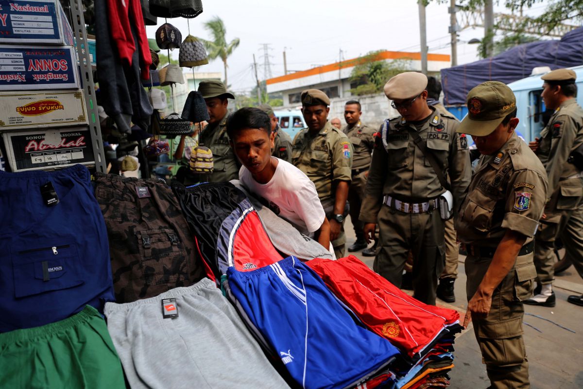 Petugas Satpol PP melakukan penertiban kepada pedagang kaki lima yang berjualan di kawasan Pasar Tanah Abang, Jakarta, Rabu (17/5/2017). Penertiban dilakukan setiap hari menyusul mulai banyaknya PKL yang berjualan di trotoar dan jalan kawasan Pasar Tanah Abang.