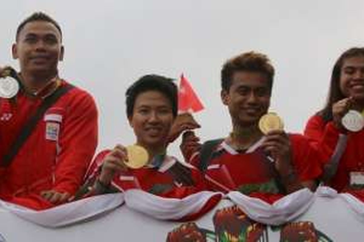 Para peraih medali Olimpiade Rio 2016, Eko Yuli Irawan, Liliyana Natsir, Tontowi Ahmad, Sri Wahyuni Agustiani (dari kiri ke kanan), berpose dengan medali yand didapat di atas Bandros di Bandara Soekarno-Hatta, Jakarta, Selasa (23/8/2016).