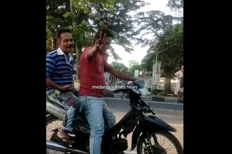 Tangkapan layar video unggahan akun Instagram @medanheadlines.news yang memperlihatkan pelaku pemalakan mengacungkan dua jari bertanda V. Pelaku memalak pedagang buah di Jalan Gatot Subroto pada Sabtu (4/9/2021) yang sedang sepi jualannya.