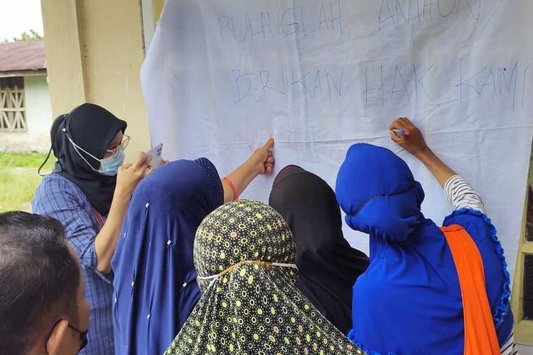 Ratusan petani Kopsa-M di Desa Pangkalan Baru, Kecamatan Siak Hulu, Kabupaten Kampar, Riau, membubuhkan tanda tangan di atas kain putih sebagai petisi meminta gaji mereka dibayarkan, Minggu (7/11/2021).