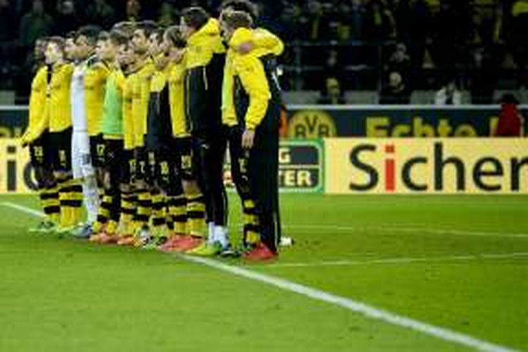 Para pemain Borussia Dortmund berdiri sejajar untuk menghormati salah satu suporter yang meninggal dunia akibat serangan jantung, saat laga Bundesliga kontra Mainz 05 di Stadion Signal Iduna Park, Minggu (13/3/2016).