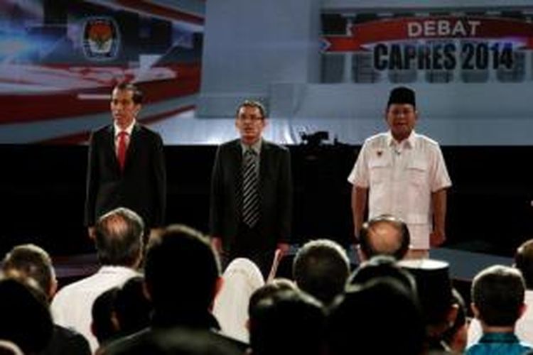 Kedua calon presiden didampingi oleh moderator yaitu Guru Besar bidang Ekonomi Universitas Brawijaya Ahmad Erani Yustika (tengah), menyanyikan lagu Indonesia Raya sebelum dalam debat capres 2014 putaran kedua dimulai, di Hotel Gran Melia, Kuningan, Jakarta, Minggu (15/6/2014).