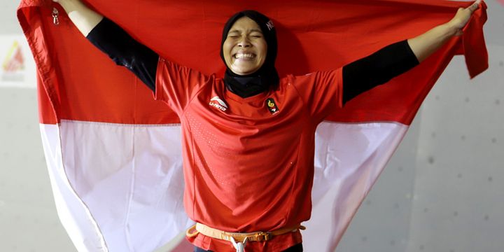 Atlet panjat tebing Indonesia Aries Susanti Rahayu mengibarkan Bendera Merah Putih setelah berhasil meraih medali emas pada kategori speed Asian Games 2018 di Arena Panjat Tebing Jakabaring Sport City, Palembang, Sumatera Selatan, Kamis (23/8/2018).