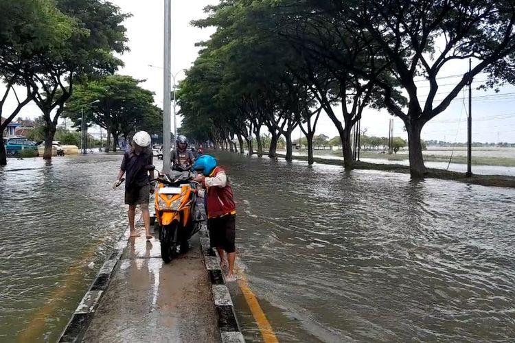 Para pemotor memanfaatkan trotoar untuk menghindari jalur Pantura Demak - Kudus yang masih tergenang. (KOMPAS.COM/NUR ZAIDI