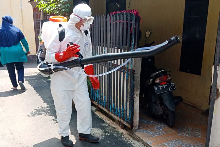 Petugas PPSDM Geominerba melakukan penyemprotan disinfektan di rumah warga.