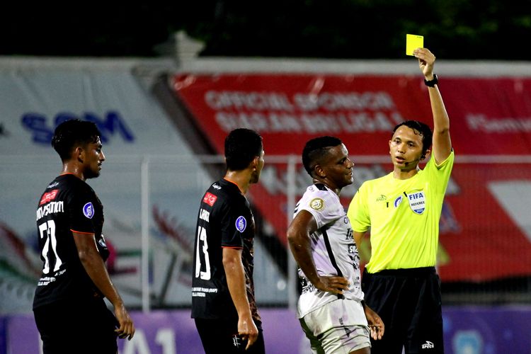 Wasit Budi Nurcahya memberi kartu kuning kepada Pemain asing Bali United Ebber Bessa saat pertandingan pekan 30 Liga 1 2021-2022 melawan Persiraja Banda Aceh yang berakhir dengan skor 0-1 di Stadion Kompyang Sujana Denpasar, Jumat (11/3/2022) malam.