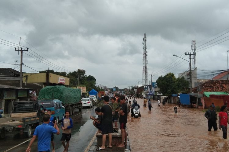 Banjir menggenangi Jalan Ahmad Yani, Dusun Pajaten, Desa Dawuhan Tengah, Kecamatan Cikampek, Karawang, Minggu (7/2/2021). Akibatnya sejumlah kendaraan mogok dan terjadi kemacetan panjang.