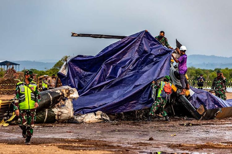 Petugas gabungan menutup bangkai helikopter yang jatuh menggunakan terpal di Kawasan Industri Kendal (KIK), Kabupaten Kendal, Jawa Tengah, Sabtu (6/6/2020). Belum diketahui penyebab jatuhnya helikopter jenis MI-17 bernomor registrasi HA 5141 milik TNI-AD yang mengakibatkan empat awak tewas dan lima awak lainnya dilarikan ke rumah sakit.