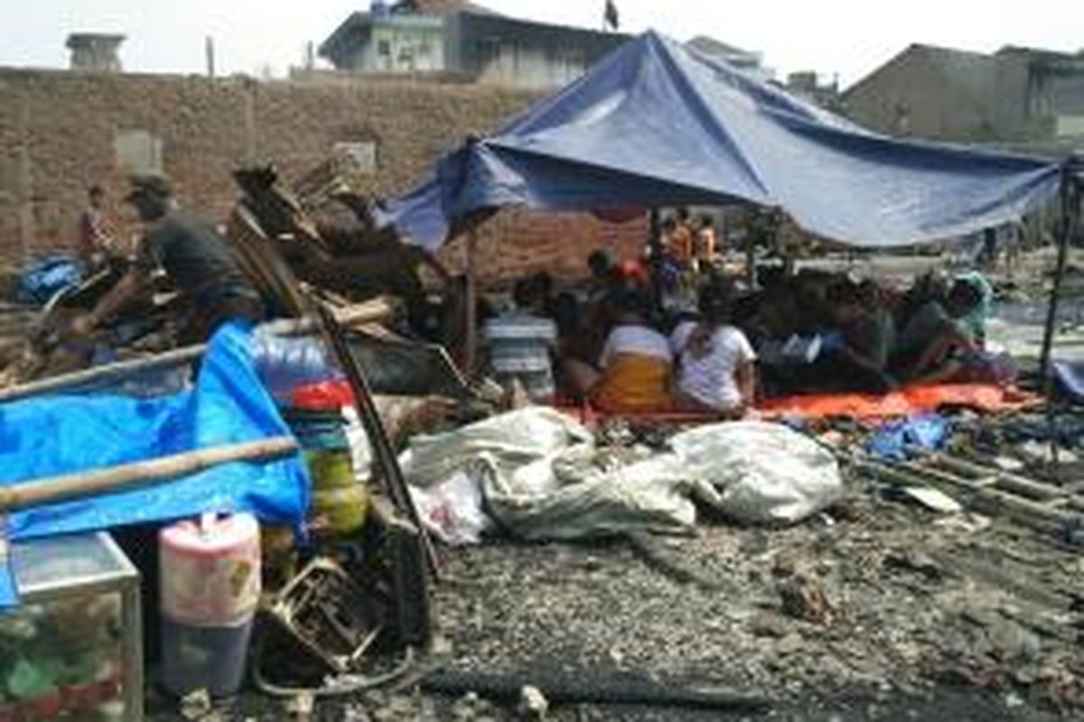 Enok (50) dan beberapa warga lainnya mendirikan tenda di lokasi bekas rumah mereka yang terbakar, Minggu (27/9/2015).