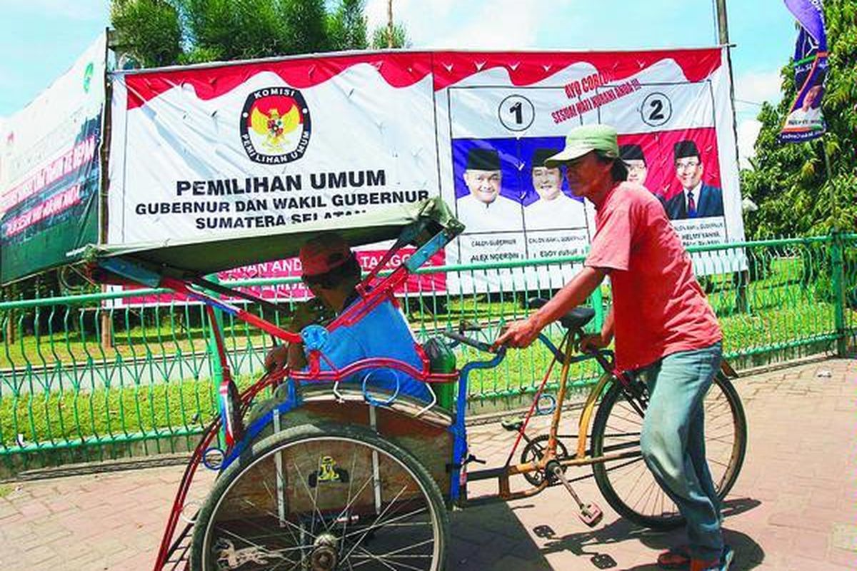 Warga melintas di dekat baliho berukuran besar untuk menyosialisasikan Pilkada Sumatera Selatan yang terpampang di sejumlah sudut kota Palembang, seperti di Bundaran Air Mancur, Kamis (21/8). Baliho yang dikeluarkan KPU Sumsel itu merupakan upaya sosialisasi pilkada dalam mengajak masyarakat menggunakan hak pilihnya pada 4 September mendatang.  